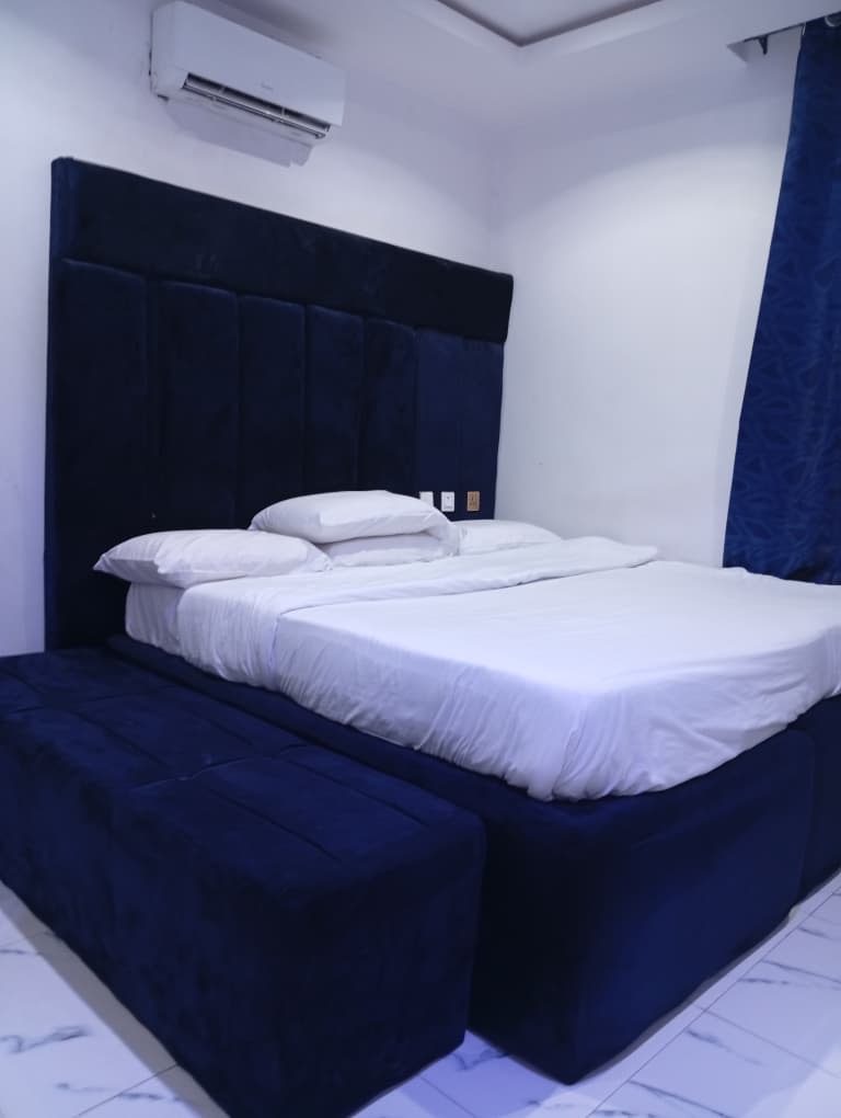 Guest room with navy velvet bed and crisp white linens