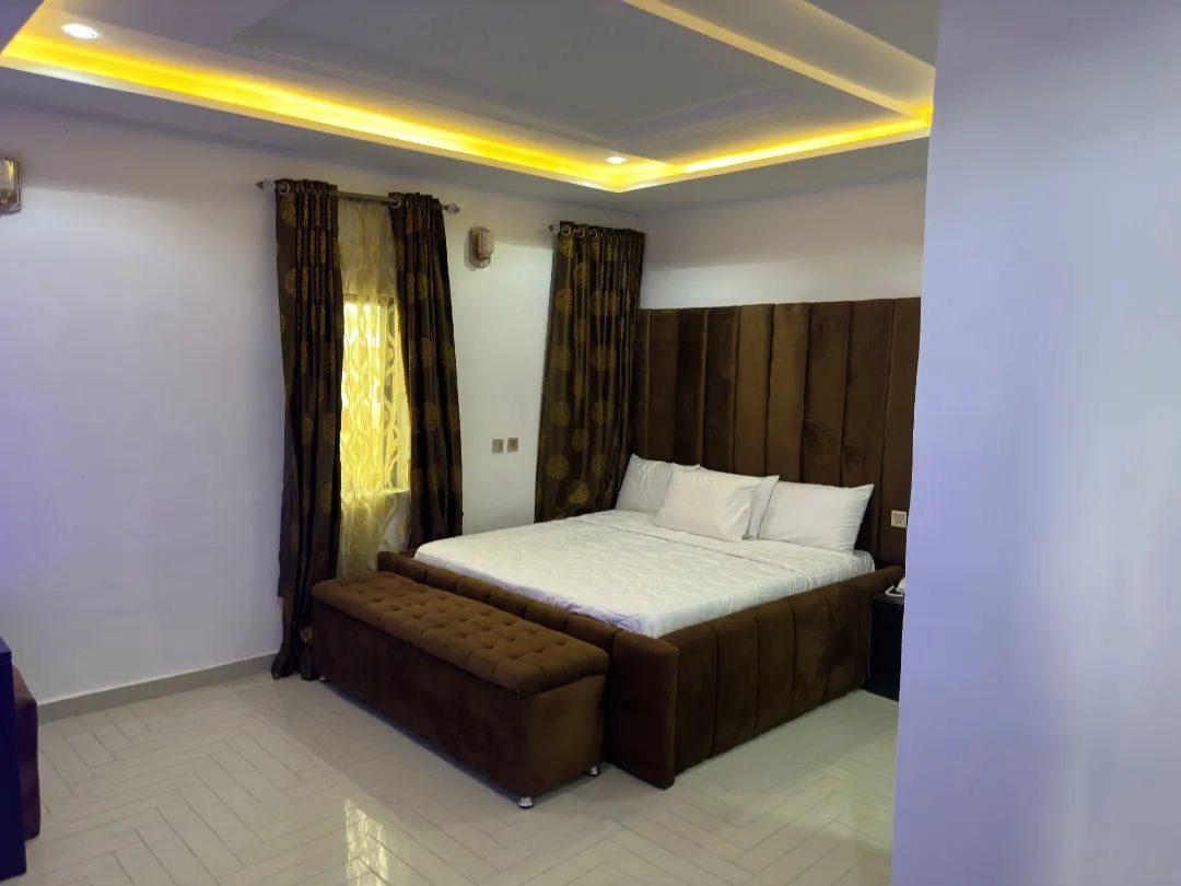 Brown velvet king room with draped curtains